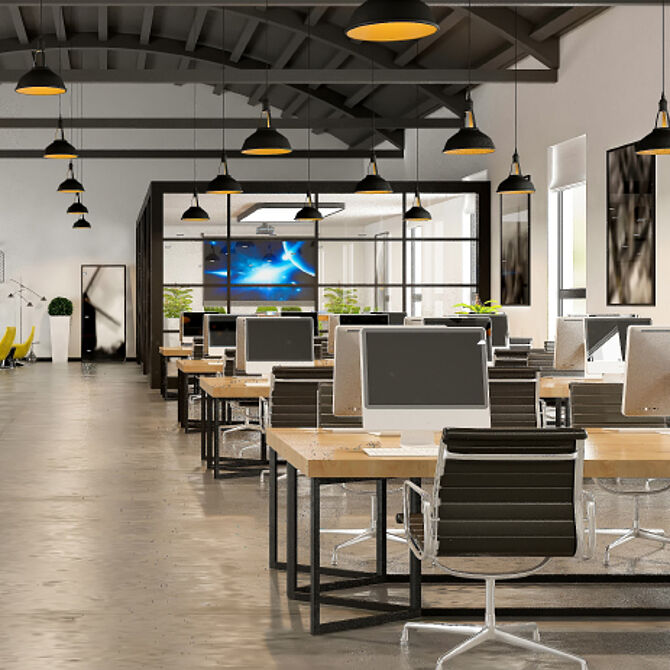 Großraumbüro im industriellen Stil mit modernen Schreibtischen, Computern, ergonomischen Stühlen und stilvoller Beleuchtung.