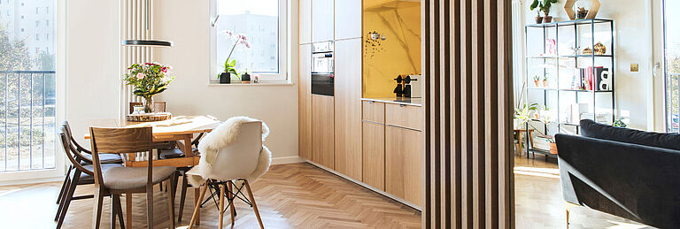 Modernes, lichtdurchflutetes Wohn- und Esszimmer mit offener Küche, Holzmöbeln und stilvoller Einrichtung im skandinavischen Stil.