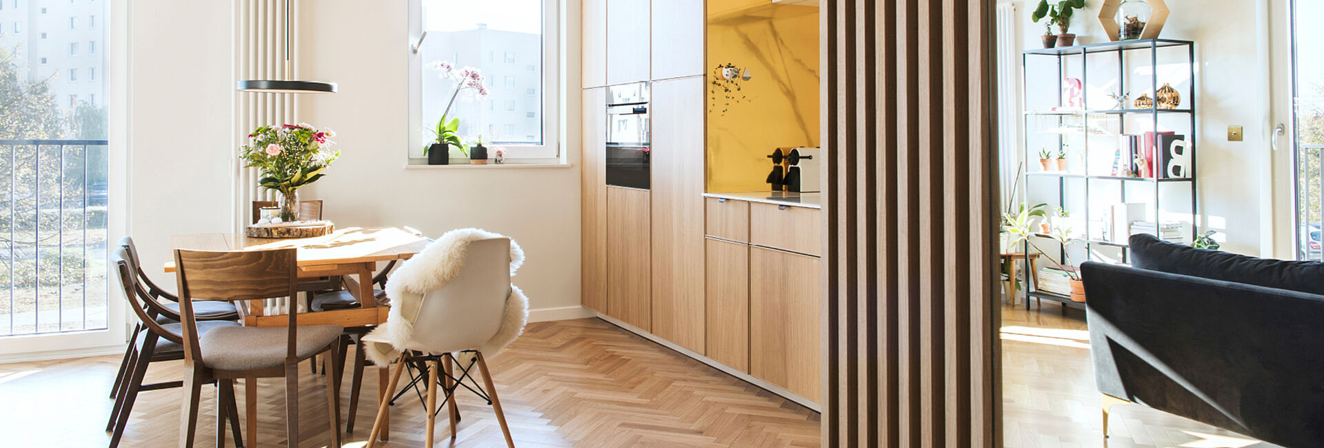 Modernes, lichtdurchflutetes Wohn- und Esszimmer mit offener Küche, Holzmöbeln und stilvoller Einrichtung im skandinavischen Stil.